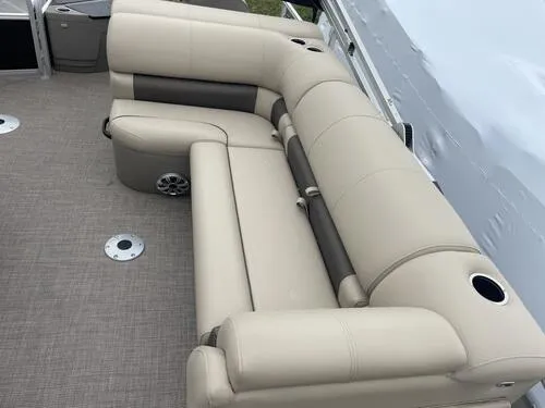 Slide: The Image of 2023 Sun Tracker SportFish 20 DLX pontoon boat with beige seating and cup holders. - 8