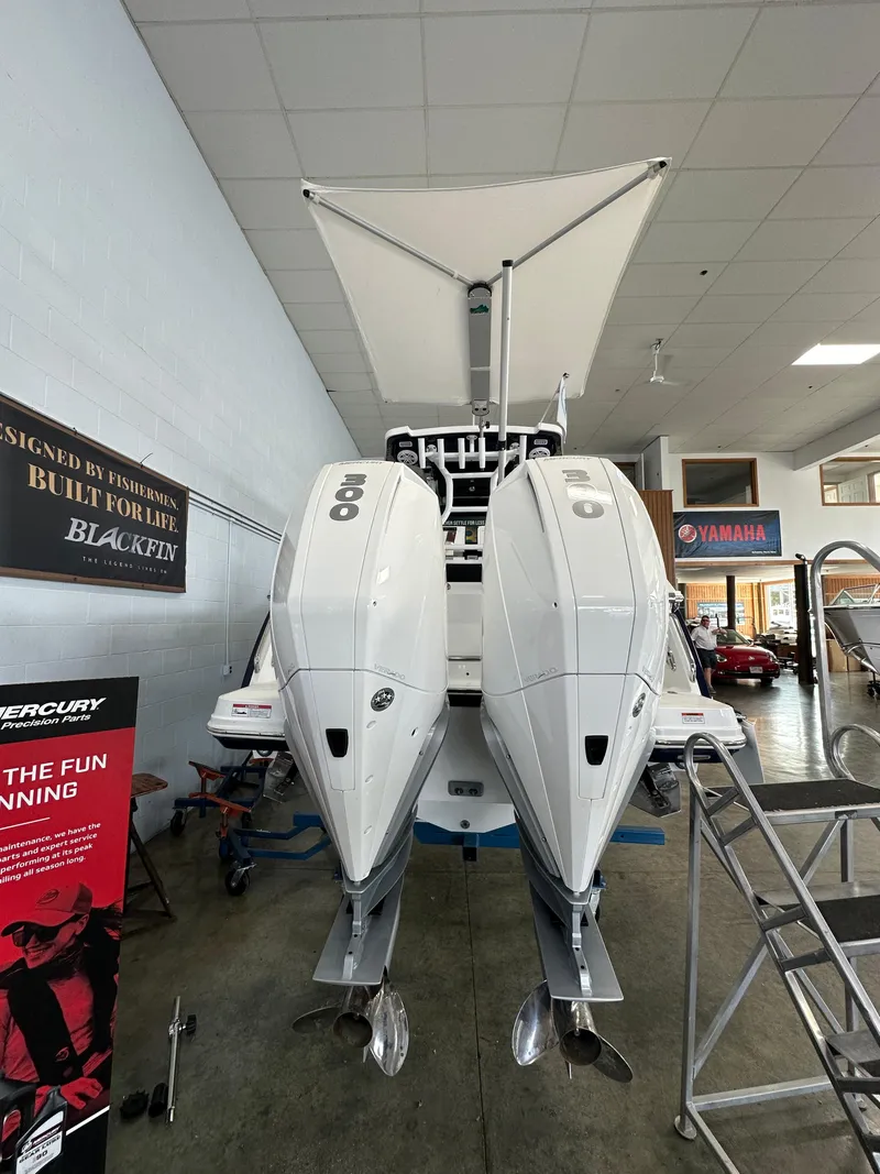 Slide: The Image of 2023 Blackfin 272 CC boat with twin outboard engines in showroom. - 11