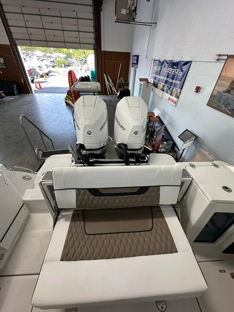 Slide: The Image of 2023 Blackfin 272 CC boat with twin outboard engines in a showroom. - 13