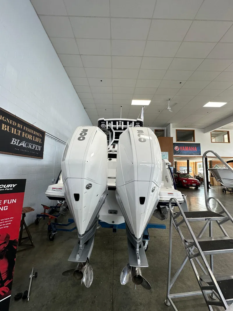 Slide: The Image of 2023 Blackfin 272 CC boat with twin outboard engines in showroom. - 15