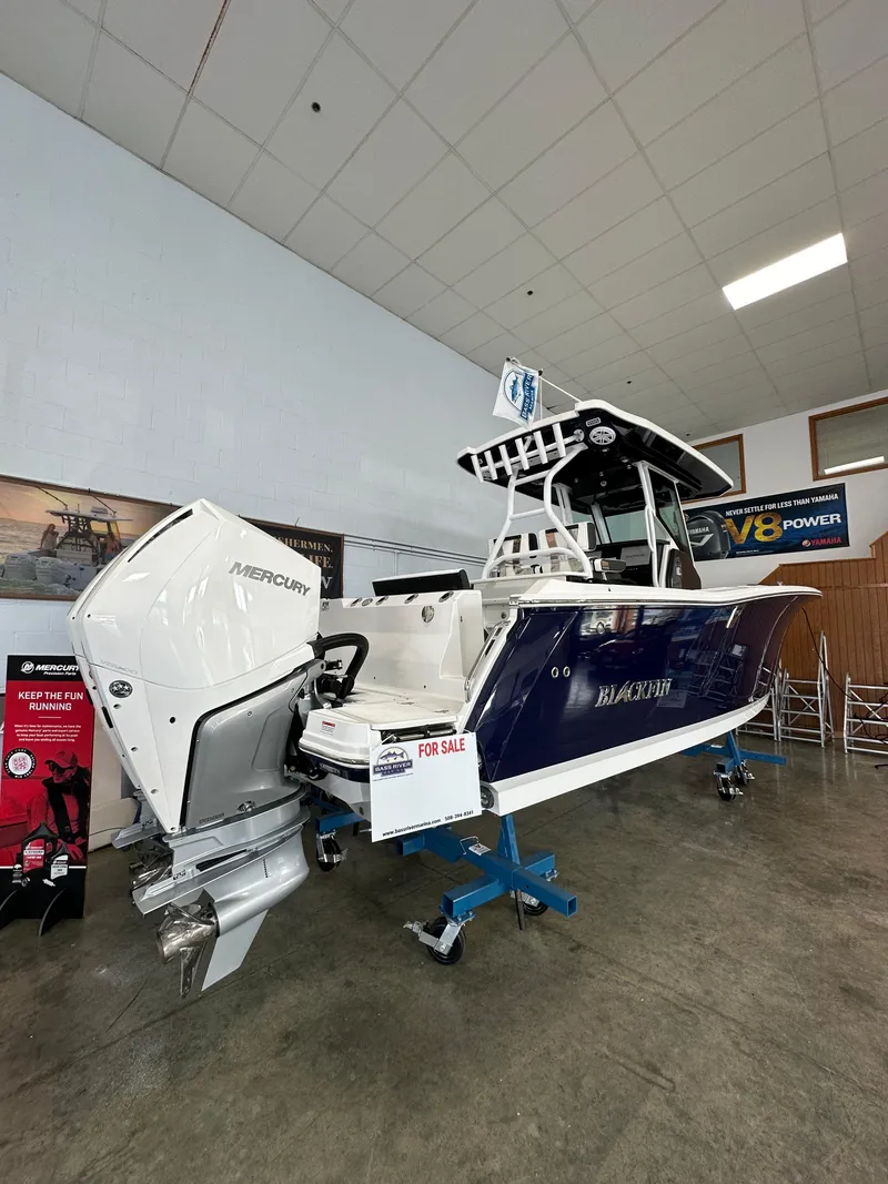 Slide: The Image of 2023 Blackfin 272 CC boat with Mercury outboard engine on display indoors. - 16