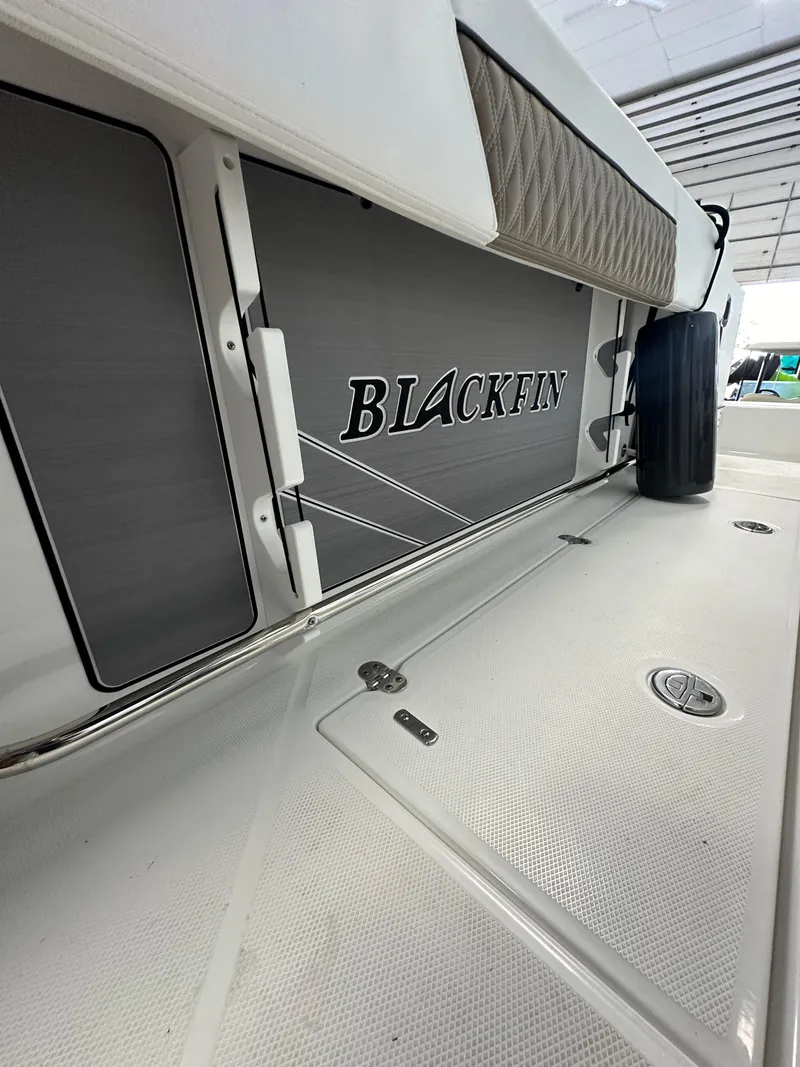Slide: The Image of 2023 Blackfin 272 CC boat interior with logo and storage compartments. - 8