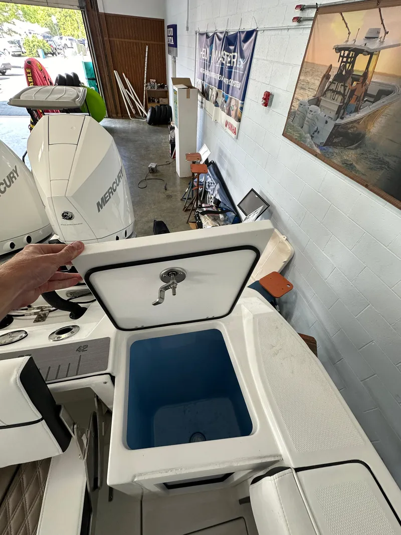 Slide: The Image of 2023 Blackfin 272 CC boat with open storage compartment in showroom. - 9