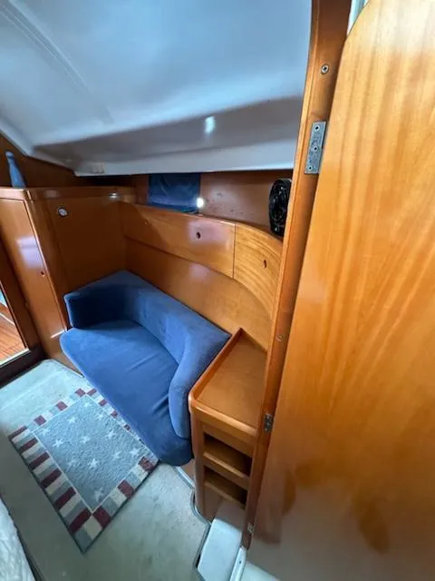 Slide: The Image of Interior of 1997 Beneteau 42S7 yacht with blue sofa and wooden cabinetry. - 16