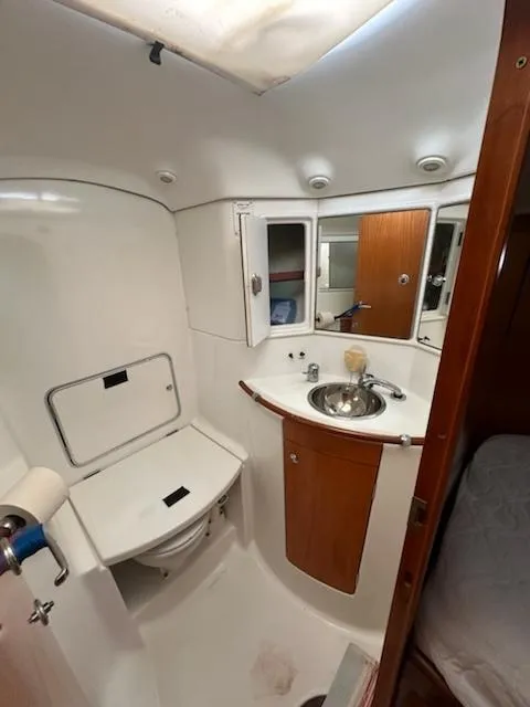 Slide: The Image of 1997 Beneteau 42S7 yacht bathroom with sink, mirror, and storage cabinets. - 17
