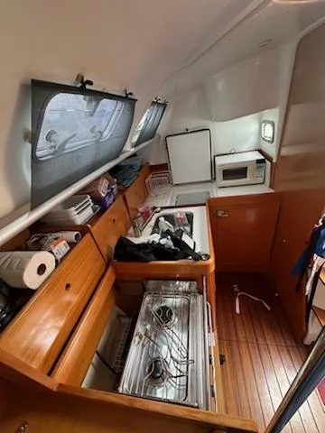 Slide: The Image of Interior of 1997 Beneteau 42S7 sailboat kitchen with stove, microwave, and storage. - 20