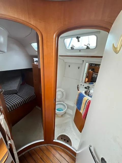 Slide: The Image of Interior of 1997 Beneteau 42S7 sailboat showing cabin and bathroom with wooden finishes. - 21