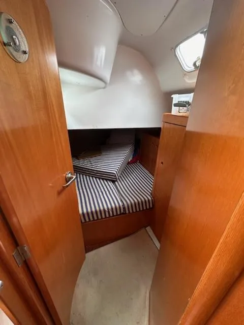 Slide: The Image of Cozy cabin interior of 1997 Beneteau 42S7 sailboat with striped bedding. - 22