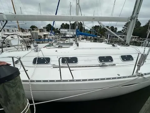 Slide: The Image of 1997 Beneteau 42S7 sailboat docked at marina, overcast sky, side view. - 25