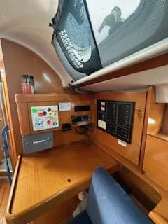 Slide: The Image of Navigation station inside 1997 Beneteau 42S7 sailboat with control panels and seating. - 3