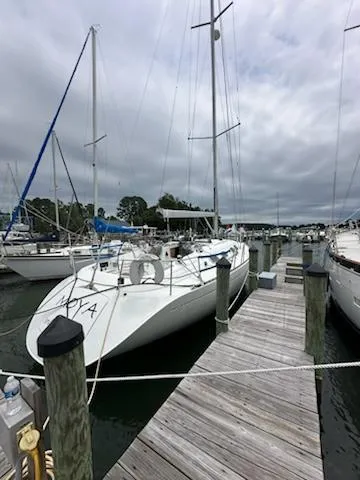 Slide: The Image of 1997 Beneteau 42S7 sailboat docked at a marina under cloudy skies. - 9