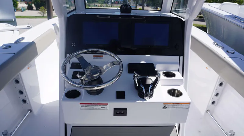 Slide: The Image of 2025 Sportsman 261 Heritage boat console with steering wheel and dual screens. - 13
