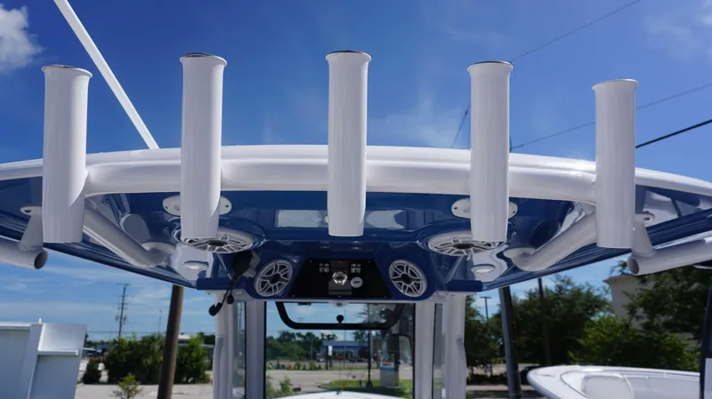 Slide: The Image of 2025 Sportsman 261 Heritage boat with rod holders and speakers under a clear blue sky. - 16