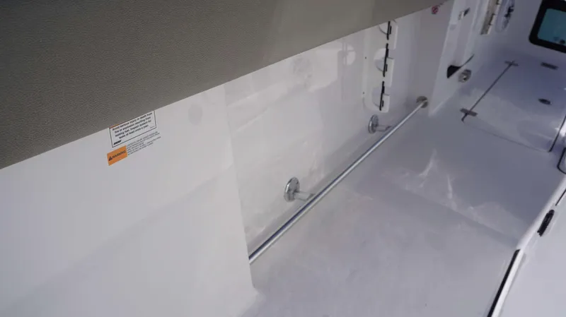 Slide: The Image of 2025 Sportsman 261 Heritage boat interior with storage compartments and safety warning label. - 9