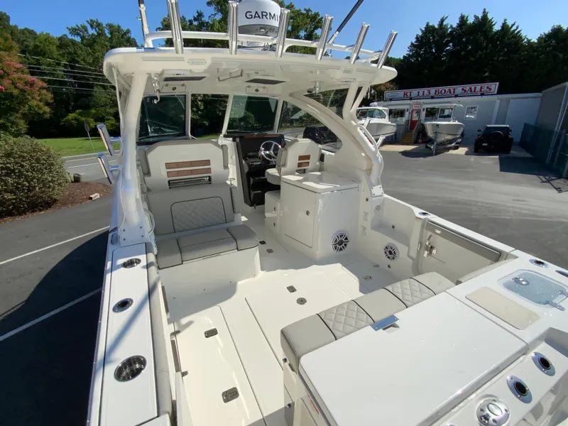 Slide: The Image of 2025 Pursuit DC 306 Dual Console boat interior at a dealership. - 10