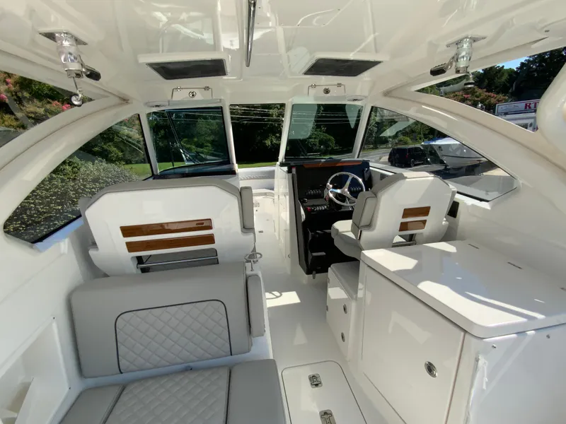 Slide: The Image of 2025 Pursuit DC 306 Dual Console boat interior with white and gray seating. - 17