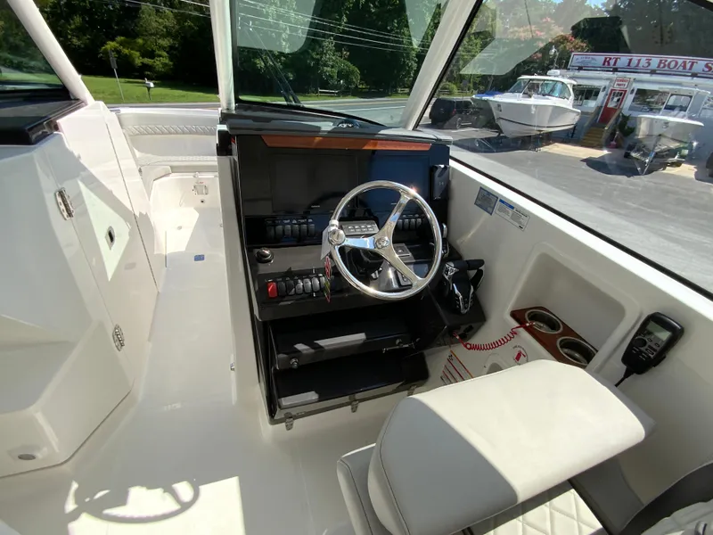 Slide: The Image of 2025 Pursuit DC 306 Dual Console boat interior with steering wheel and controls. - 18
