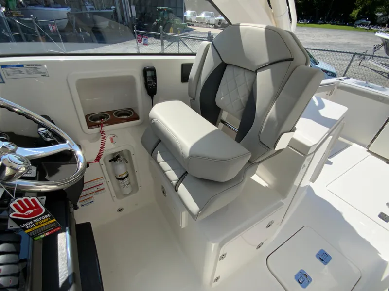 Slide: The Image of 2025 Pursuit DC 306 Dual Console boat interior with captain's chair and control panel. - 20