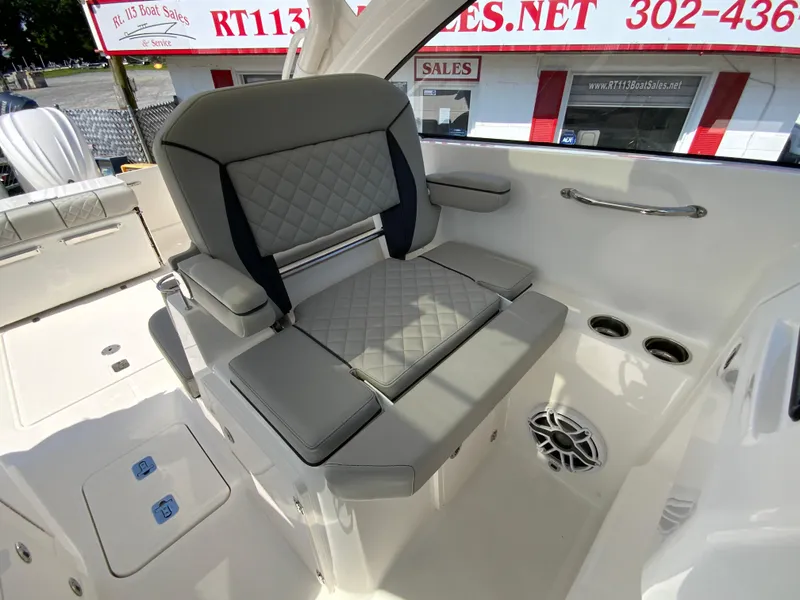 Slide: The Image of 2025 Pursuit DC 306 Dual Console boat interior with gray cushioned seating and cup holders. - 22