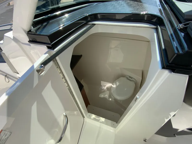 Slide: The Image of 2025 Pursuit DC 306 Dual Console boat interior with compact marine toilet. - 26