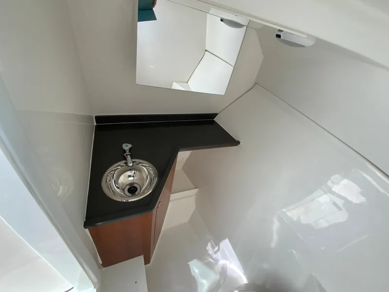 Slide: The Image of 2025 Pursuit DC 306 Dual Console boat interior with sink and mirror. - 27