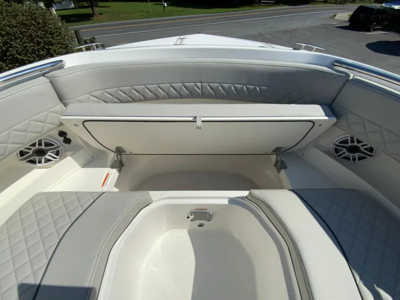 Slide: The Image of 2025 Pursuit DC 306 Dual Console boat with open storage compartment and cushioned seating. - 29