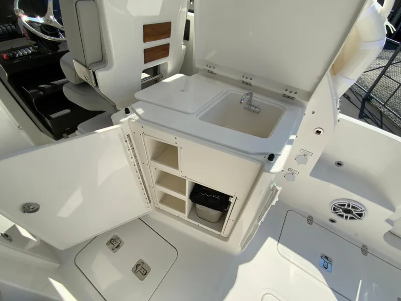 Slide: The Image of 2025 Pursuit DC 306 Dual Console boat interior with sink and storage compartments. - 39