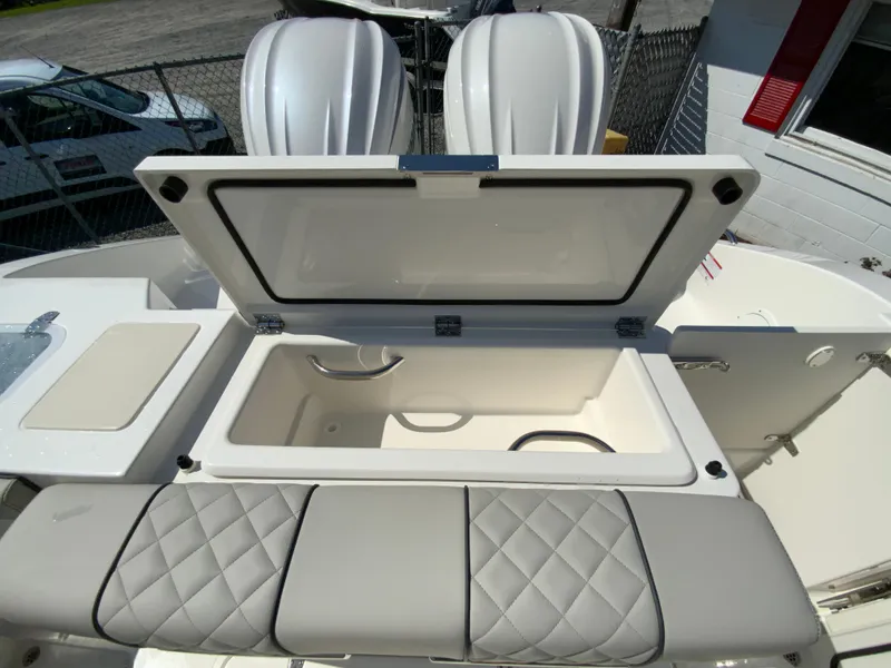 Slide: The Image of 2025 Pursuit DC 306 Dual Console boat with open storage compartment and cushioned seating. - 45