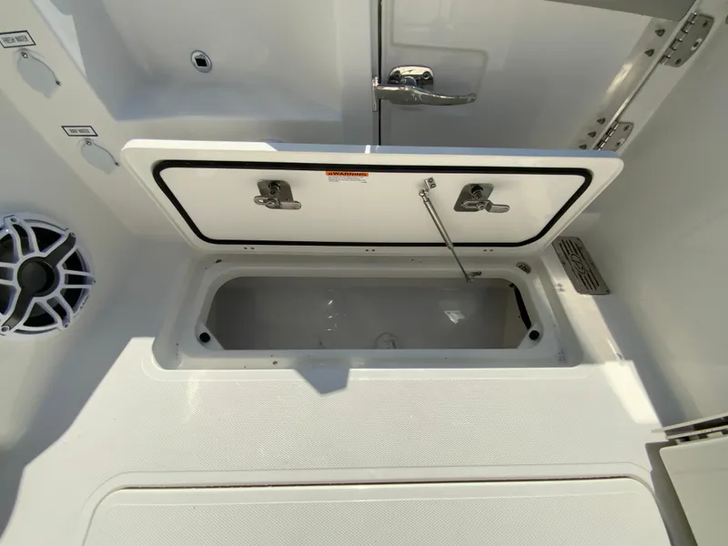 Slide: The Image of 2025 Pursuit DC 306 Dual Console storage compartment with open lid. - 46