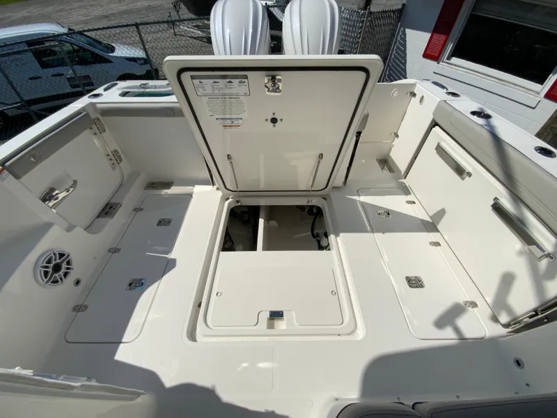 Slide: The Image of 2025 Pursuit DC 306 Dual Console boat with open storage compartments. - 49