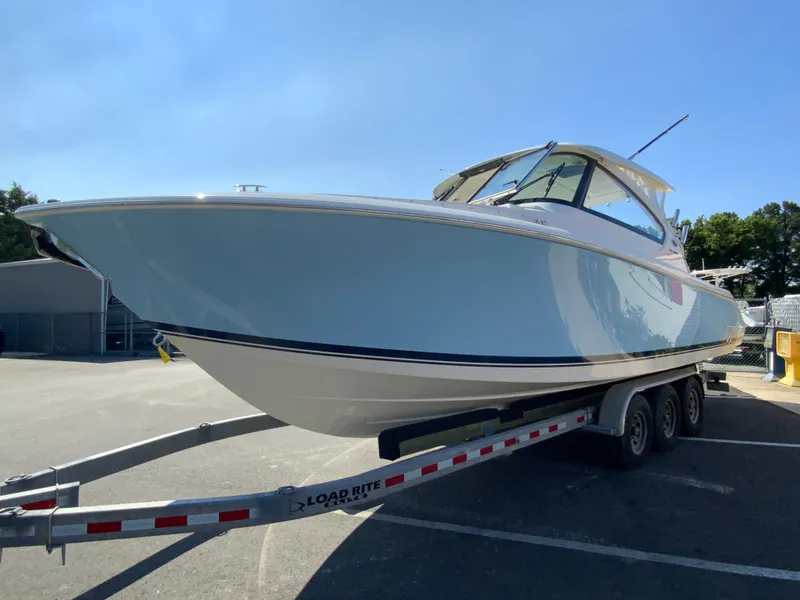 Slide: The Image of 2025 Pursuit DC 306 Dual Console boat on a trailer in a parking lot. - 5