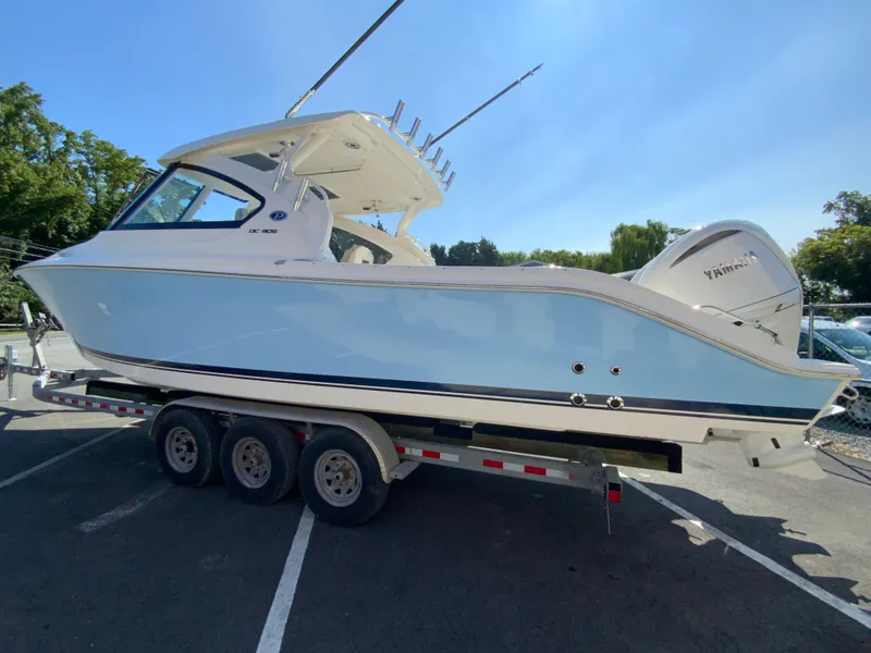 Slide: The Image of 2025 Pursuit DC 306 Dual Console boat on a trailer in a parking lot. - 7