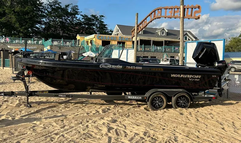 The Image of 2024 Warrior 238 DC boat on sandy beach with trailer. - 0