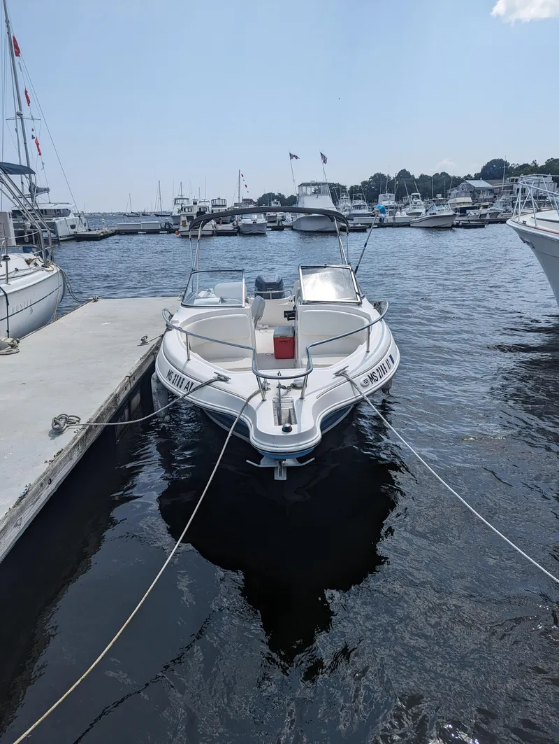 Slide: The Image of 2004 Wellcraft 220 Sportsman DC boat docked at a marina. - 5