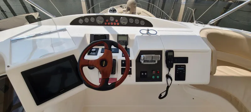Slide: The Image of 2006 Viking Sport Cruisers 61 Flybridge helm with steering wheel, navigation, and control panels. - 11