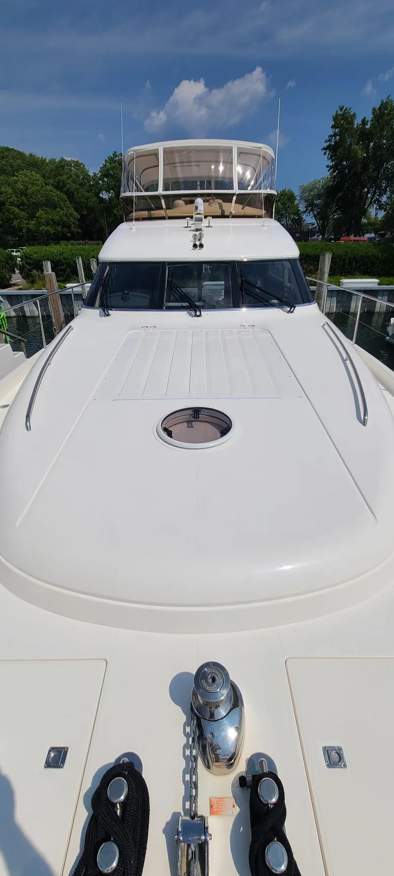 Slide: The Image of 2006 Viking Sport Cruisers 61 Flybridge yacht docked, showcasing its sleek design and spacious deck. - 8