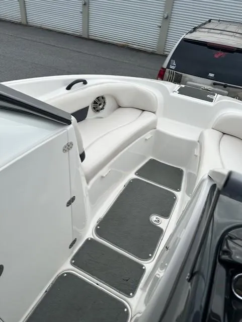 Slide: The Image of 2007 Yamaha Boats AR 210 interior, white seating, gray flooring, and storage compartments. - 10