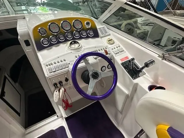 Slide: The Image of 2004 Powerquest 340 Vyper boat cockpit with purple steering wheel and control panel. - 11