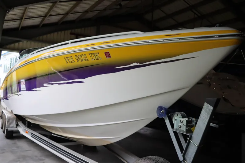 Slide: The Image of 2004 Powerquest 340 Vyper boat with yellow and purple design on trailer. - 21