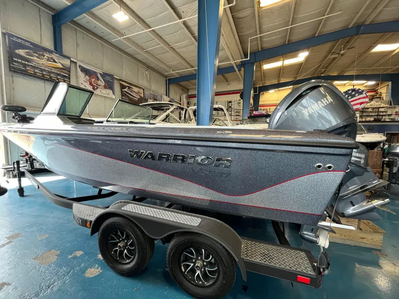 The Image of 2024 Warrior 21-21 boat on trailer in showroom with Yamaha outboard motor. - 1