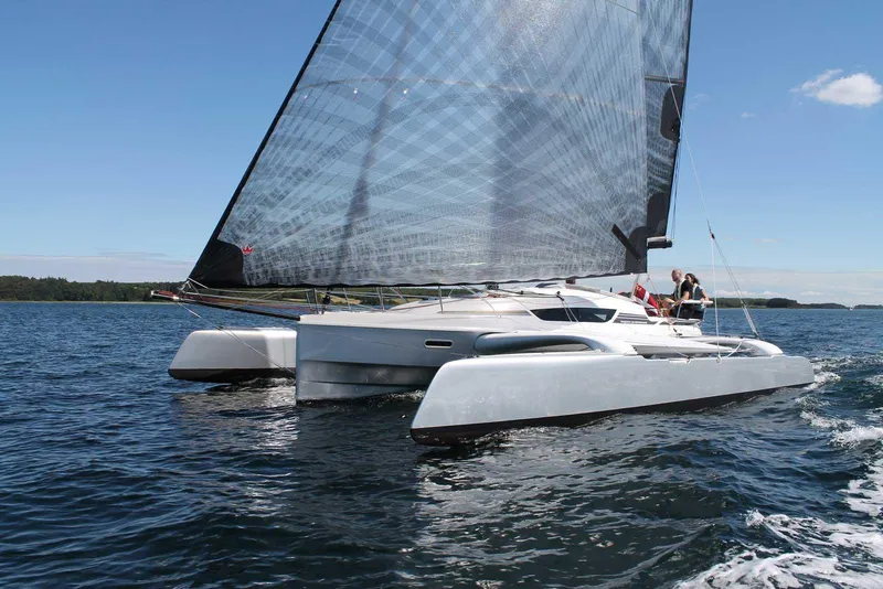 The Image of 2026 Dragonfly 28 trimaran sailing on open water under clear skies. - 0