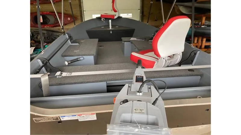 Slide: The Image of 2024 Smoker Craft Big Fisherman 16 boat interior with red and white seating. - 5