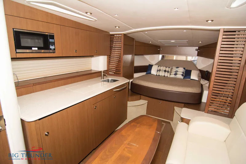 Slide: The Image of Luxurious interior of 2016 Sea Ray 370 Sundancer yacht with modern kitchen and cozy sleeping area. - 48