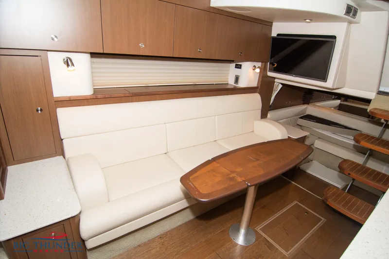 Slide: The Image of Interior of 2016 Sea Ray 370 Sundancer with modern seating and wooden table. - 49