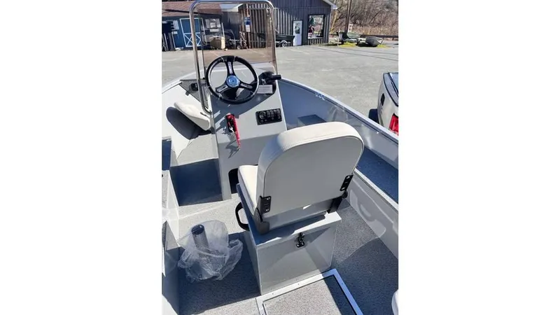 Slide: The Image of 2024 Smoker Craft 160 Freedom CC boat interior with steering console and seating. - 8