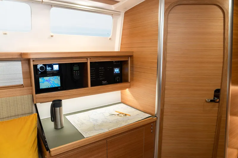 Slide: The Image of Navigation station in 2026 Dragonfly 40 sailboat with map and control panels. - 12