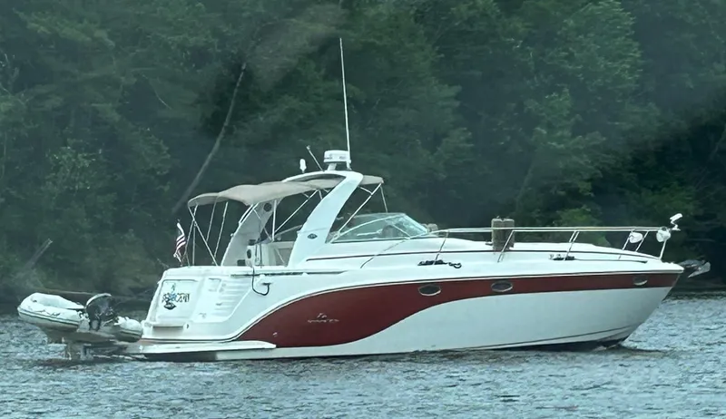 The Image of 2006 Rinker 390 Express Cruiser on a lake with forested background. - 1