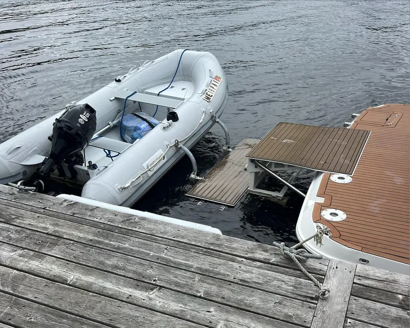 Slide: The Image of 2006 Rinker 390 Express Cruiser docked with inflatable boat on water. - 6