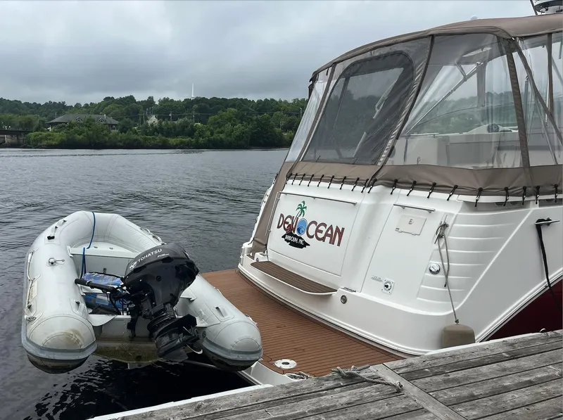 Slide: The Image of 2006 Rinker 390 Express Cruiser docked with inflatable dinghy on calm water. - 7