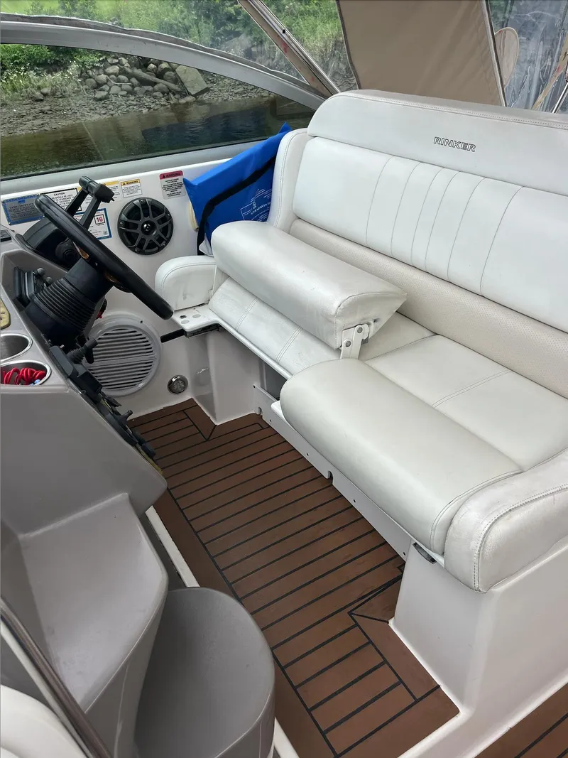 Slide: The Image of 2006 Rinker 390 Express Cruiser cockpit with white leather seating and wooden flooring. - 9